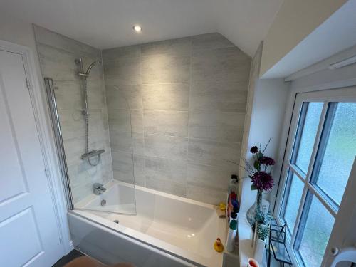 a bathroom with a shower and a bath tub at Rose Cottage 