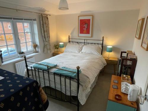 a bedroom with a bed and two lamps and a table at Rose Cottage 