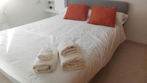 Una cama con toallas blancas encima. en RESIDENCIAL ALCOY Apartahotel en Alcoy