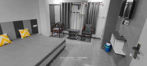 1 dormitorio con 1 cama, 2 sillas y escritorio en Hotel Karan, en Kathua