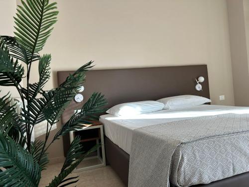una camera con un letto e una grande pianta verde di Villa Angeli a Roma