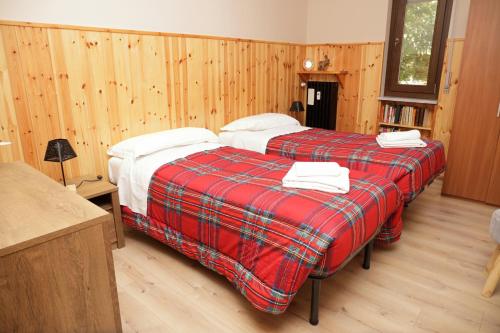 2 Betten in einem Zimmer mit Holzwänden in der Unterkunft Casa Vacanze Limone in Limone Piemonte