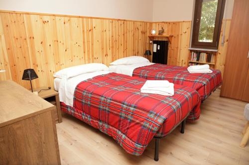 two beds in a room with wooden walls at Casa Vacanze Limone in Limone Piemonte