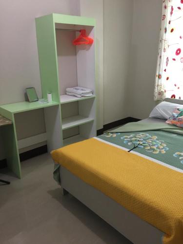 una piccola camera con letto e scrivania di AGB Anchorage Inn, studio room a Manila