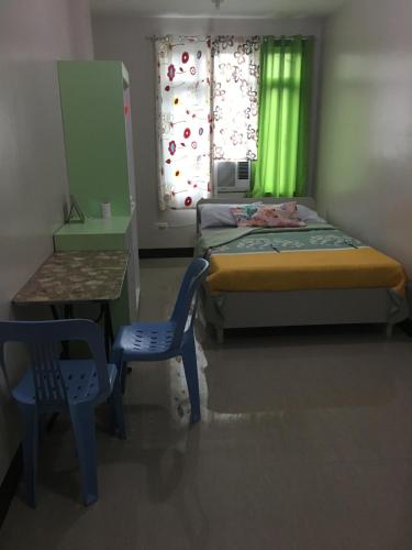 una piccola camera con letto, tavolo e sedia di AGB Anchorage Inn, studio room a Manila