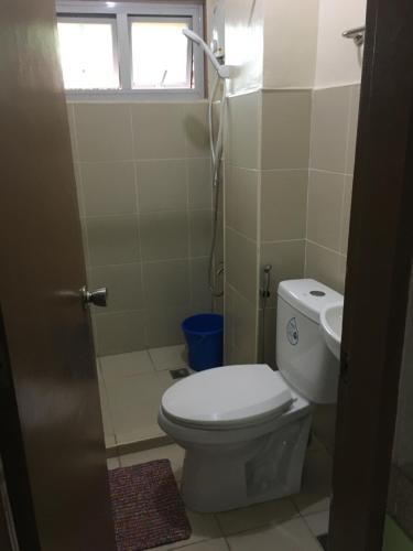 a bathroom with a toilet and a window at AGB Anchorage Inn, studio room in Manila