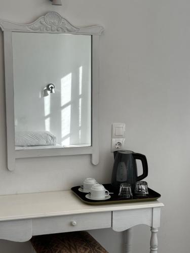 a counter with a mirror and a coffee maker on it at HOTEL MOHITERO in Kamari