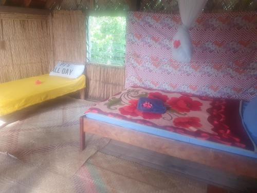 Zimmer mit 2 Betten in einem Zimmer mit Blumen in der Unterkunft Imaio home stay in Ipenyen