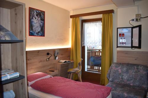 Habitación pequeña con cama y ventana en Albergo Pensione Sport, en Arabba