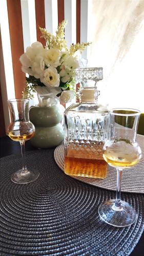 two glasses and a bottle of whiskey on a table at BalkanHill2 S37 Pekovic green in Zlatibor