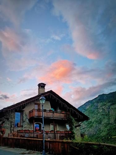 a building with a balcony on the side of it at La Fattoria di Roven in Gignod
