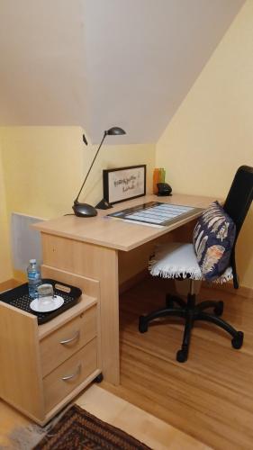 un bureau avec un bureau, une chaise et une lampe dans l'établissement Chambre chez l'habitant vue sur jardin, parking, à Le Rheu