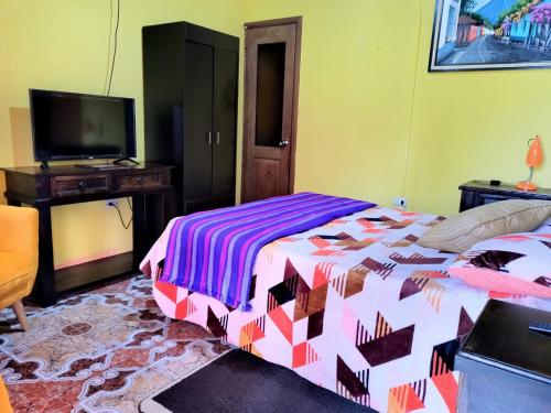 um quarto com uma cama e uma televisão. em Hotel Casa Tecpán em Pamanzana