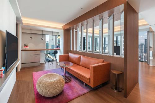 a living room with a couch and a table at W Osaka in Osaka