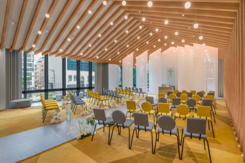 a large room with tables and chairs and windows at W Osaka in Osaka
