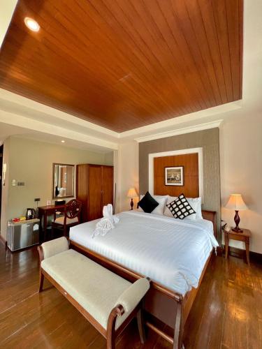 a bedroom with a large bed with a wooden ceiling at Yotaka Bangkok Hotel in Bangkok