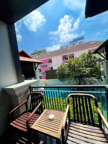 a balcony with a wooden bench and a table at Yotaka Bangkok Hotel in Bangkok
