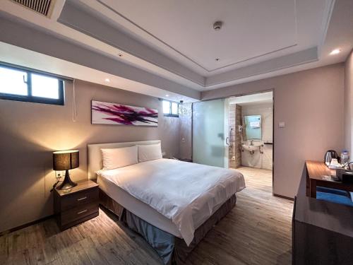 a bedroom with a large bed and a bathroom at Royal Fine Hotel in Kaohsiung