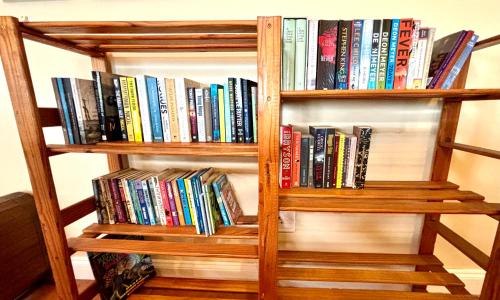 a book shelf filled with lots of books at Touchstone Cottage in Hilton