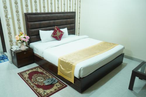 a bedroom with a bed and a table with flowers at Grand Mostafa Hotel Ababil in Sylhet