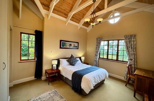a bedroom with a bed and two windows at Touchstone Cottage in Hilton