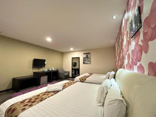 a hotel room with two beds and a tv at I Garden Hotel in Ipoh