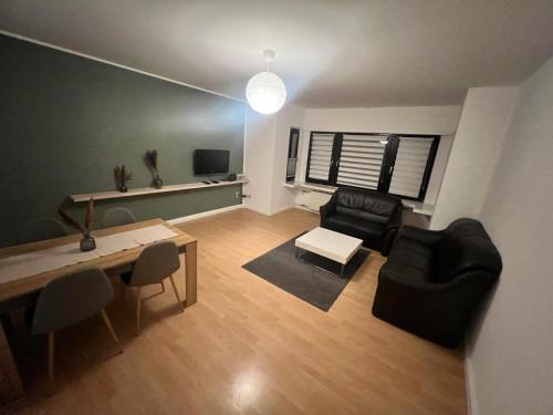 een woonkamer met een bank en een tafel en stoelen bij 2,5 Räume 4 Einzelbetten in Krefeld