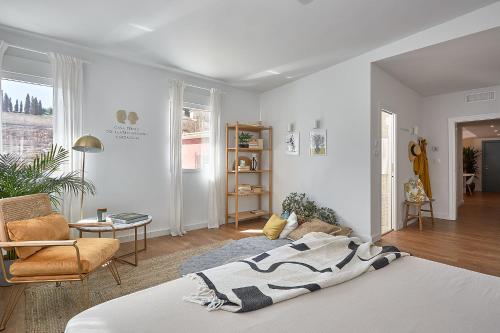 ein weißes Schlafzimmer mit einem Bett und ein Wohnzimmer in der Unterkunft Casa Terma del Teatro in Cartagena