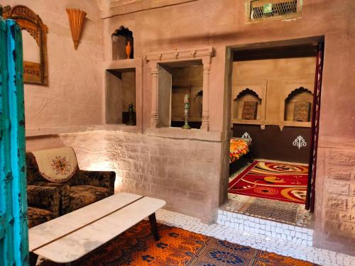 Casa De Jodhpur في جودبور: غرفة بها أريكة وطاولة ومرآة