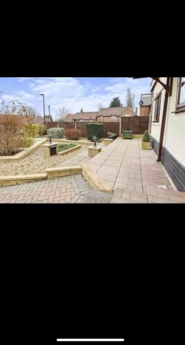 un patio de ladrillo con bancos y un edificio en Dorterry House, en Ilkeston