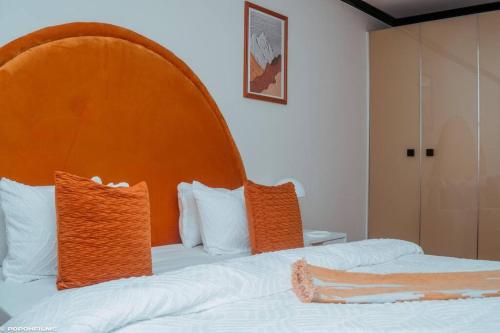 a bedroom with a bed with an orange headboard at Sunset View-Luxury Apartment in Sandton