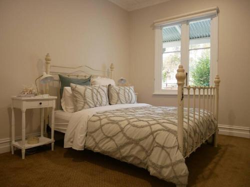 ein Schlafzimmer mit einem weißen Bett und einem Fenster in der Unterkunft Old Koondrook Bakery in Koondrook