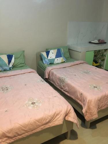 - deux lits assis l'un à côté de l'autre dans une pièce dans l'établissement AGB Anchorage Inn, studio room - 2 single beds, à Manille