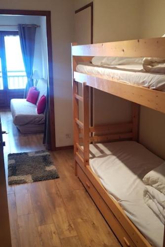 une chambre avec deux lits superposés et un canapé dans l'établissement Studio porte du Mont Blanc Combloux aux pieds des pistes, à Combloux