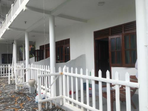 una cerca blanca frente a una casa en Asanka Surf House & Resturant, en Midigama East