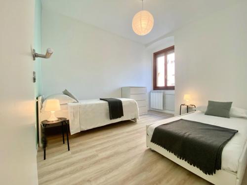 熱那亞的住宿－CasaViva - Lovely Family House at the sea in Genoa，一间卧室设有两张床、一张桌子和一个窗口