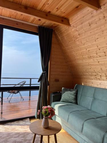 a living room with a couch and a large window at Panorama Sarpi in Batumi