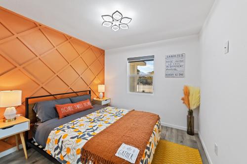 1 dormitorio con 1 cama con cabecero naranja grande en New!Palm Springs Windmill Villa-Pool/Spa/Golf/View, en North Palm Springs