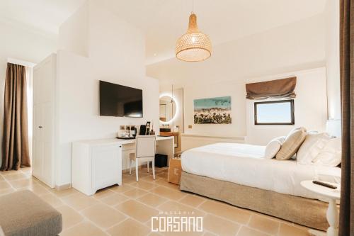 a white bedroom with a desk and a bed at Masseria Corsano in Nardò