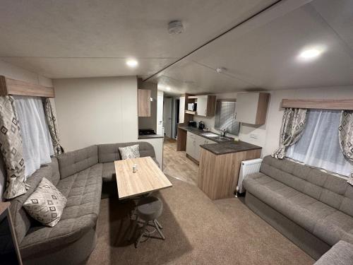 a living room with a couch and a table at Billing Aquadrome Luxury Static Caravan in Great Billing