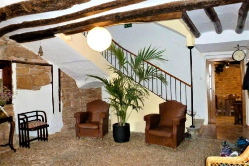 Villatuerta的住宿－La Casa Mágica，客厅配有两把椅子和盆栽植物