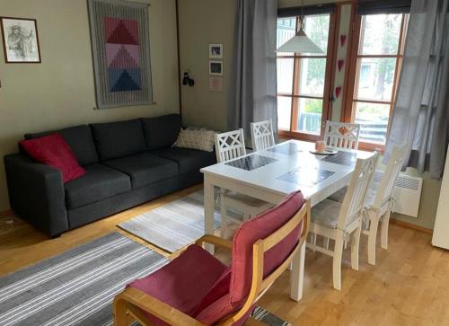 ein Wohnzimmer mit einem Tisch, Stühlen und einem Sofa in der Unterkunft Aslak Apartment in Saariselkä