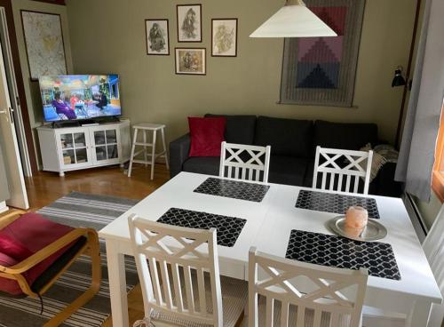 sala de estar con mesa blanca y sillas en Aslak Apartment, en Saariselkä