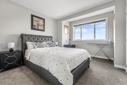 a bedroom with a large bed and a window at Sunny Walk-out Unit, Free HiSpeed Wi-Fi and Parking, Near Grocery in Calgary
