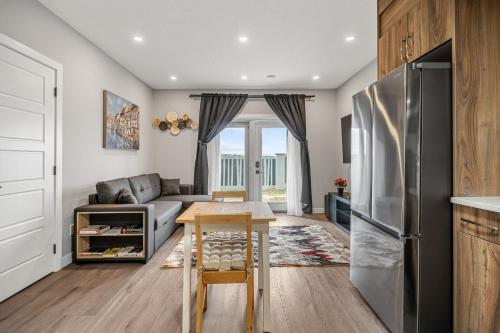 a kitchen and living room with a stainless steel refrigerator at Sunny Walk-out Unit, Free HiSpeed Wi-Fi and Parking, Near Grocery in Calgary