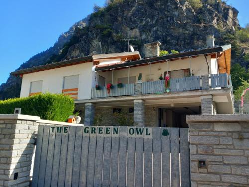 a house with a fence in front of a mountain at The Green Owl in Antey-Saint-André