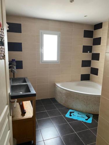 La salle de bains est pourvue d'une grande baignoire et d'un lavabo. dans l'établissement Villa familliale au calme sans vis à vis, Bbq, piscine privée, proche de la mer, à Saint-Thibéry