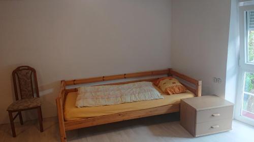 a bed with a wooden frame in a room with a chair at Monteur - Ferienwohnung Gönnern für 1 Person in Gönnern