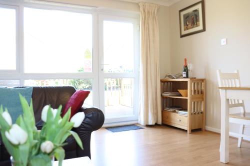 a living room with a couch and a table and a window at Corton Retreats At Waterside Park in Corton