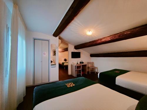 a bedroom with two beds and a table with a chair at Will's Hotel in Narbonne